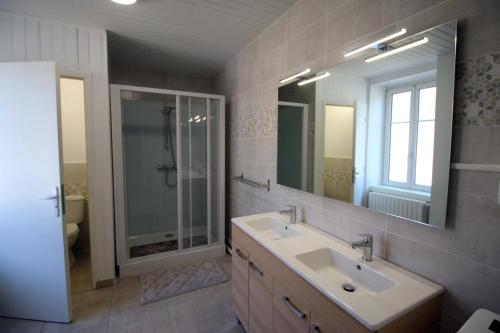 a bathroom with a sink and a shower and a mirror at Naugeat in La Roudie