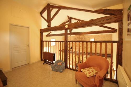 a living room with a balcony with a chair at Le petit feuillade in Saint-Laurent-sur-Gorre