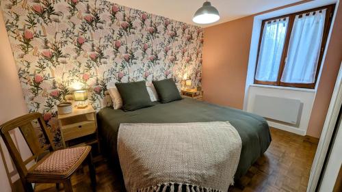 a bedroom with a bed with a floral wallpaper at La grande ourse in Panazol