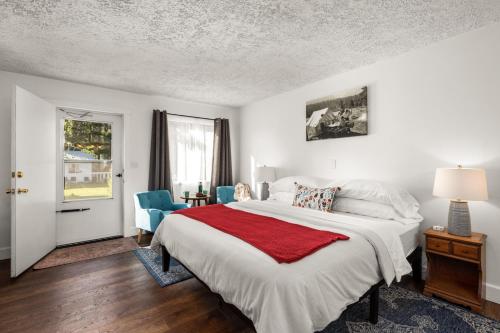 ein Schlafzimmer mit einem großen Bett und zwei blauen Stühlen in der Unterkunft Jacobson's Cottages in East Glacier Park Village