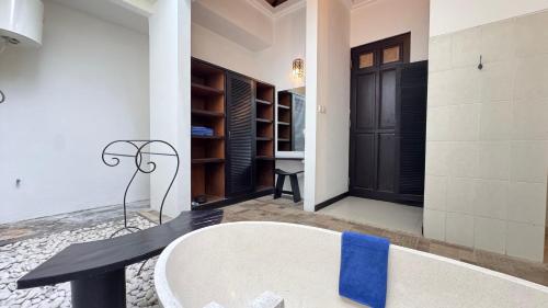 a bath tub with a blue towel on it in a bathroom at Artemis Villa Hotel in Seminyak