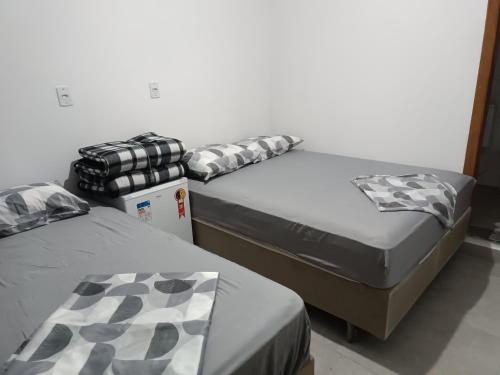 two beds sitting next to each other in a room at Suítes Monte Cristo II in Aparecida