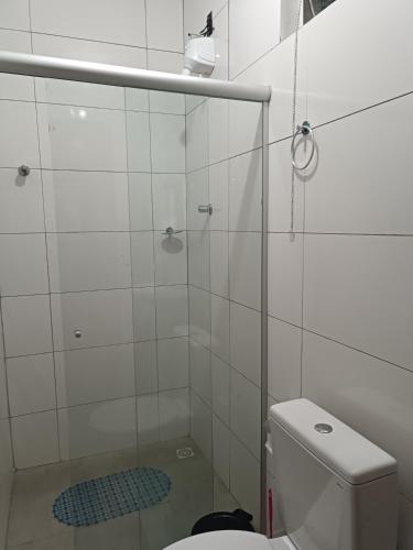 a bathroom with a glass shower with a toilet at Suítes Monte Cristo II in Aparecida