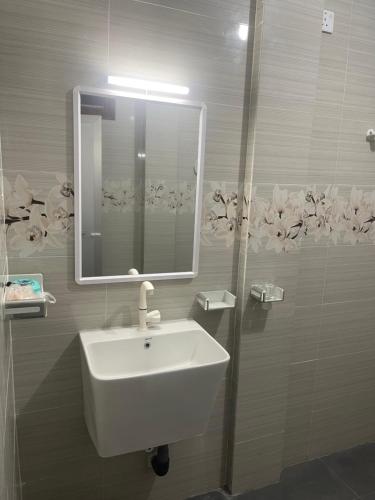a bathroom with a white sink and a mirror at The Yarl Home in Jaffna