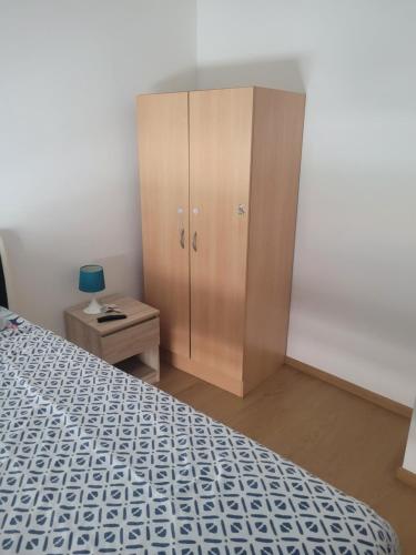 a bedroom with a bed and a wooden cabinet at Repos chez l habitant in Rennes
