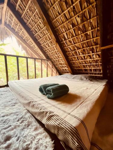 a wicker bed with a green towel on it at Las lemurias in Mazunte