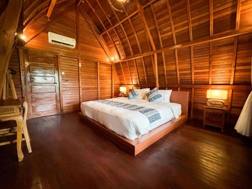 a bedroom with a bed in a wooden room at Casa Vella Cottages by AGATA in Bedugul