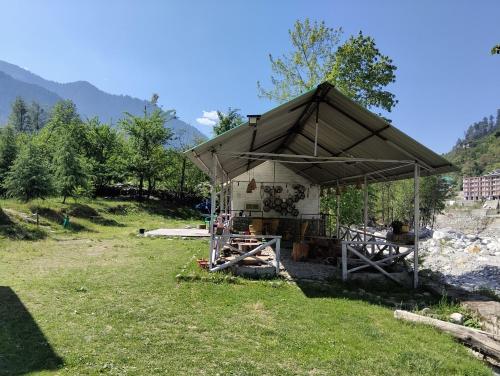 a tent in a field in the grass at Ambika Campaign Huts in Manāli