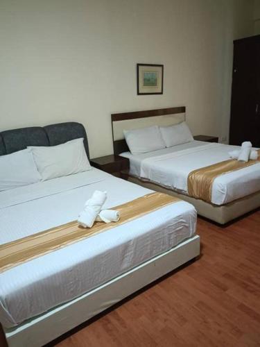 two beds in a hotel room with towels on them at Hotel Wings Kuala Lumpur in Kuala Lumpur