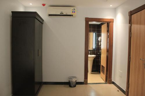 a bathroom with a toilet and a black door at فلل كوڤا بيتش - للعائلات فقط in Durat Alarous