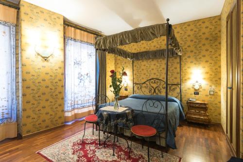 a bedroom with a canopy bed and a rug at Residenza Ave Roma in Rome