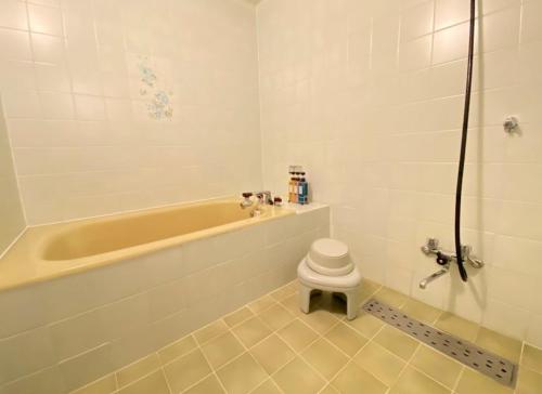 ein Badezimmer mit Badewanne und Toilette in der Unterkunft ホテルスズカ in Matsudo