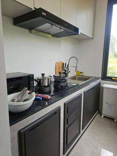 a kitchen with a sink and a stove top oven at I-DIN POOL VILLA khaoyai in Ban Nong Song Hong