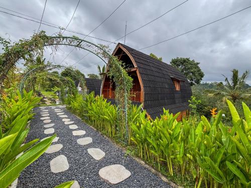 a garden with a pathway leading to a building at Casa Vella Cottages by AGATA in Bedugul