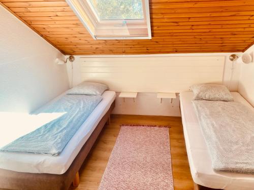 two beds in a tiny house with a window at Levendula apartman in Kehidakustány