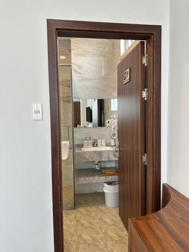 a bathroom with a sink and a toilet and a mirror at Hotel ĐÁ ĐỎ in Danang