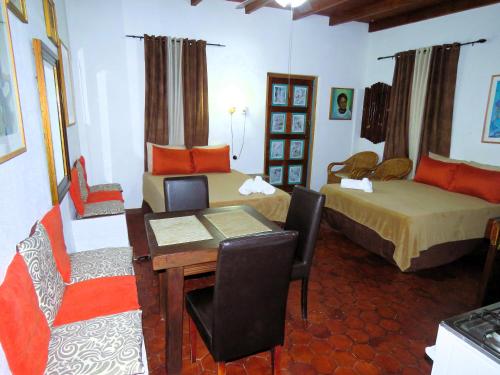 a room with two beds and a table and chairs at Artist Room Curaçao in Willemstad