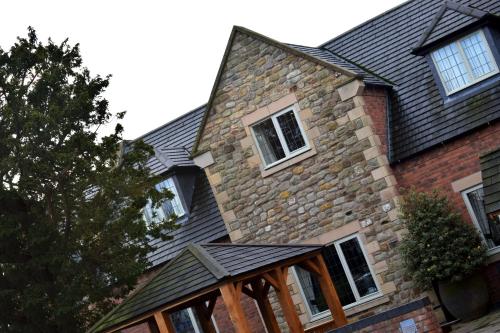 a large brick house with windows and a roof at The White Hart Inn in Alfreton