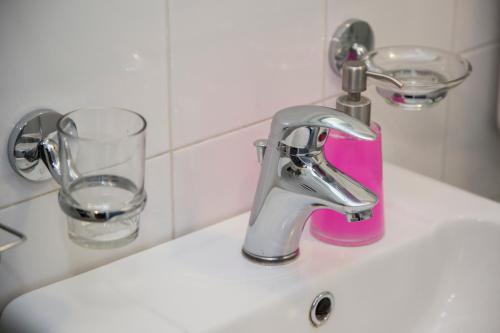 a bathroom sink with a faucet and a glass at Maison Toledo 24 in Naples