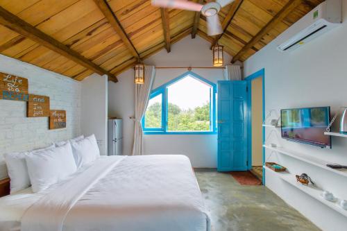 a bedroom with a large white bed and a window at Life Beach Villa in Hoi An