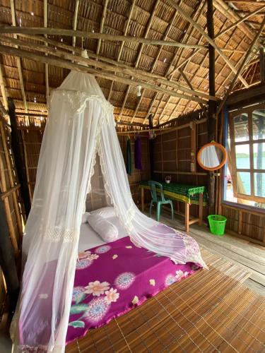 a bedroom with a bed with a mosquito net at Sunrise Raja Ampat in Besir
