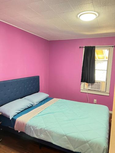 a bedroom with a bed with a pink wall at Pet friendly Newly renovated Two bedroom Property in Central Okc in Oklahoma City