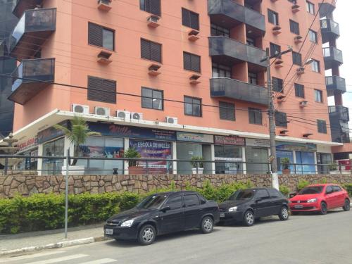 three cars parked in front of a building at Residencial Solar de Pernambuco in Guarujá