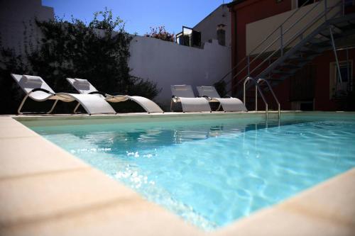 a swimming pool with chairs and a swimming pool at Spapparra B&B in Càbras