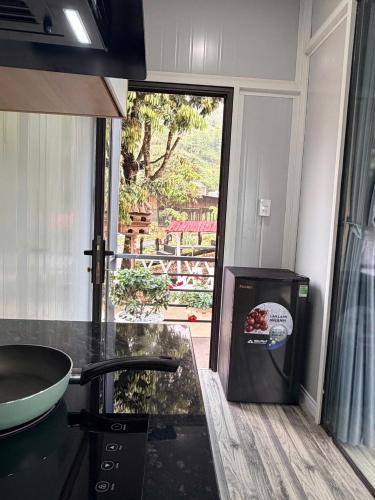 a kitchen with a counter with a sink and a window at Cỏ Mây Wonder Homestay in Mộc Châu