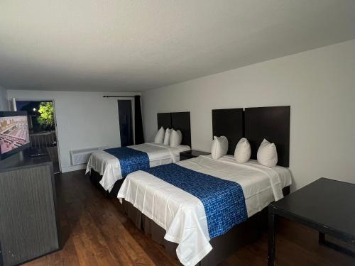 a hotel room with two beds and a table at Skylite Inn in Austin