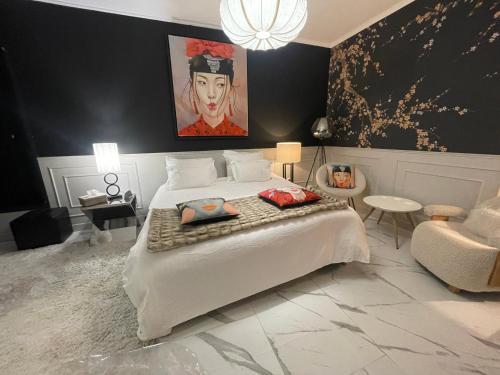 a bedroom with a large white bed and a chair at Villa Bois d'Argent in Lagraulière