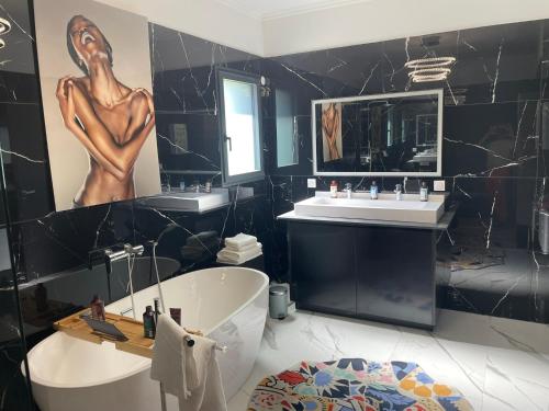 a bathroom with a tub and a sink at Villa Bois d'Argent in Lagraulière