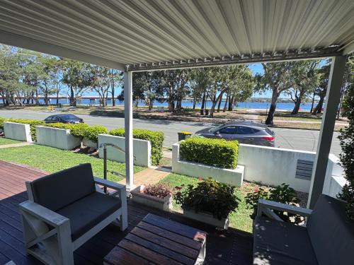 a pergola with a chair and a car on a street at Keith's on Sylvan Beach, 1 of the 3 most popular units on Bribie in Bellara