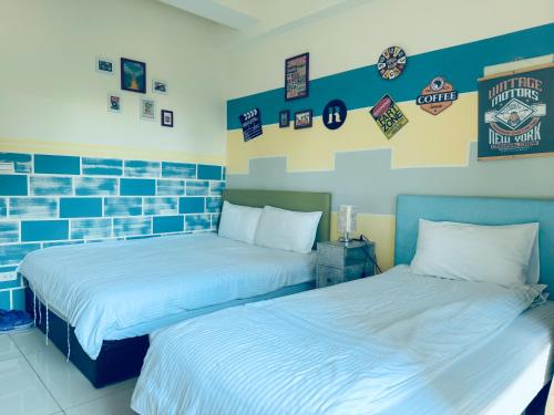 two beds in a room with blue and white at Yun He Homestay in Huwei