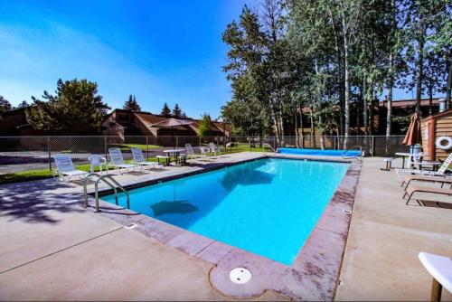 a swimming pool with chaise lounge chairs and a pool at McCall Mountain Condo Pool Sauna Deck in McCall