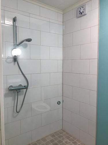 a bathroom with a shower with white tiles at E-City B&B in Tornio