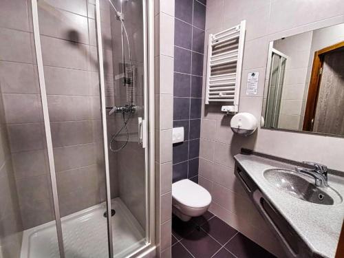 a bathroom with a shower and a toilet and a sink at Hôtel Siatel Besançon Chateaufarine in Besançon