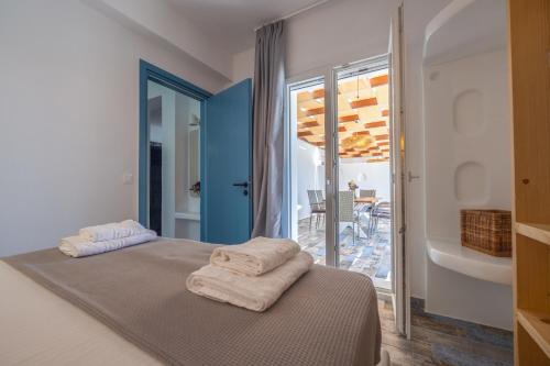 a bedroom with a bed with towels on it at Depis luxury villas naxos in Plaka