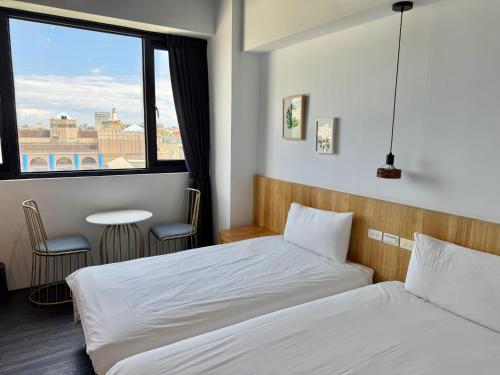 a hotel room with two beds and a window at 吾庭文旅電梯民宿 WuTing Stay in Hualien City