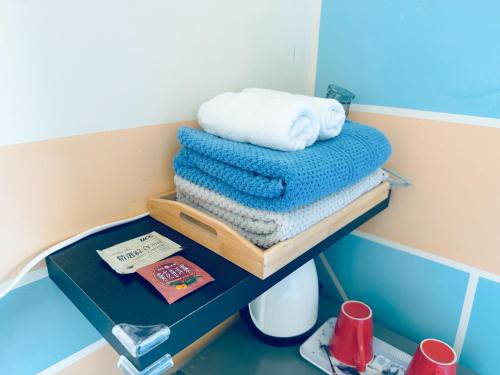 a stack of towels on a shelf in a bathroom at Yun He Homestay in Huwei