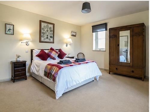 a bedroom with a bed and a dresser and a mirror at Pandy Barn Berriew in Welshpool