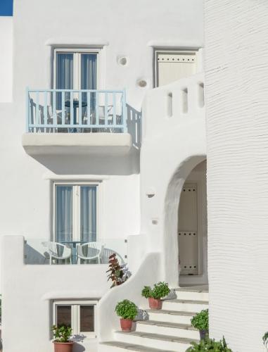 a staircase in a white building with potted plants at Naxos Island Escape Suites in Plaka