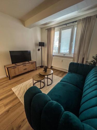 a living room with a blue couch and a television at Apartmán JT in Vyšné Opátske