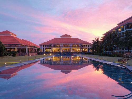 a building with a pool of water in front of it at Pullman Danang Beach Resort in Danang