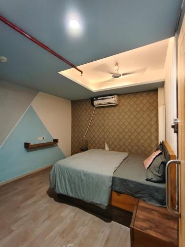 a bedroom with a bed and a ceiling at Hotel The World in Surat