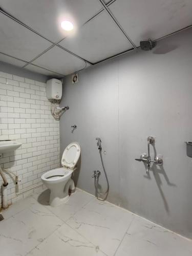 a bathroom with a toilet and a sink at Hotel The World in Surat