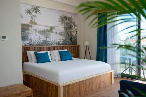 a bedroom with a large bed with blue pillows at De Suite Hotel in Antalya