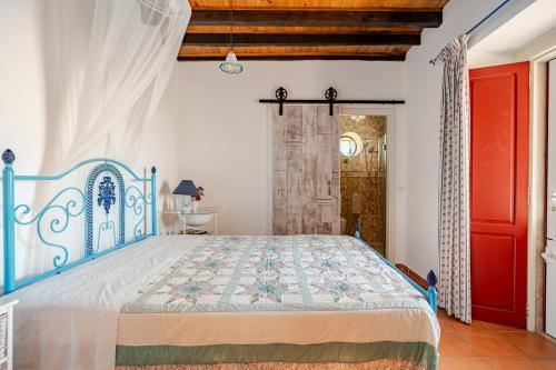 a bedroom with a blue bed and a red door at Casa na Floresta in Figueira da Foz