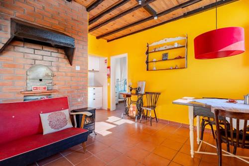 a living room with a red couch and a yellow wall at Casa na Floresta in Figueira da Foz