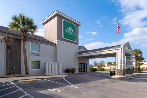 a hotel with an american flag in a parking lot at Wingate by Wyndham Myrtle Beach At Outlets in Myrtle Beach